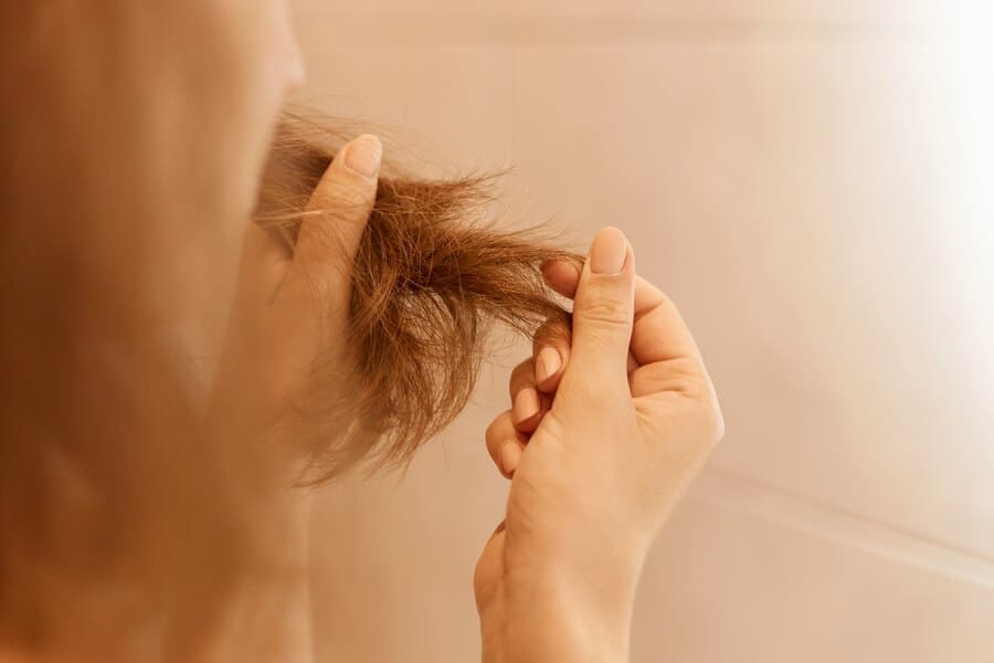 closeup-portrait-woman-hands-holding-dry-damaged-hair-eds-having-trichology-problem_176532-15683